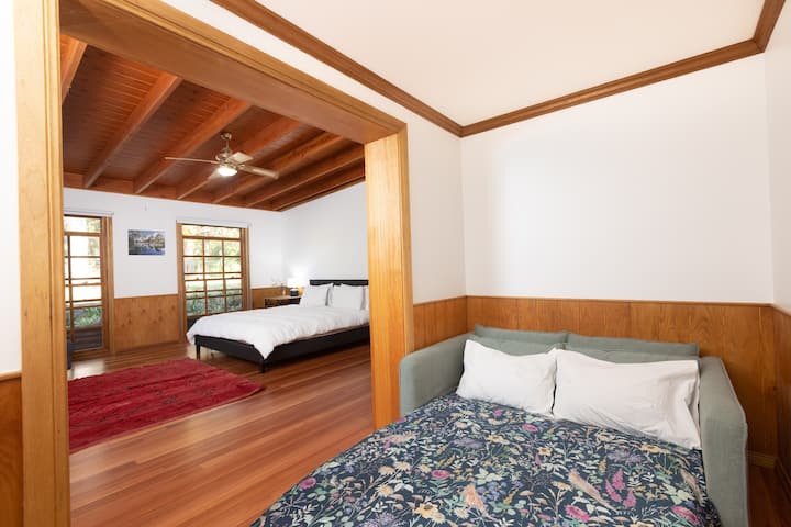 'Garden' bedroom with King Bed, Smart TV, fan and couch.
Both this bedroom and the 'Library' bedroom have adjoining areas with a sofa bed.