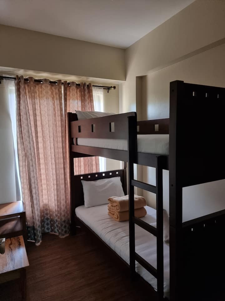 Chambre #2 avec accès au balcon derrière les rideaux.