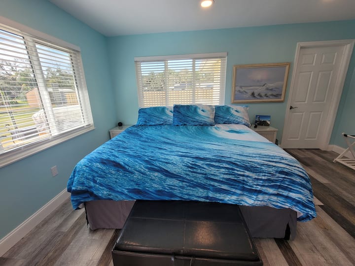 חדר שינה ליד הבריכה עם מיטת קינג וארון בגדים.