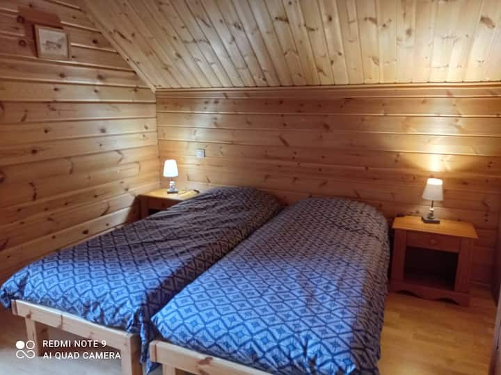 Spálňa s 2 samostatnými lôžkami s balkónom a výhľadom na lúky alebo svahy v zime.
