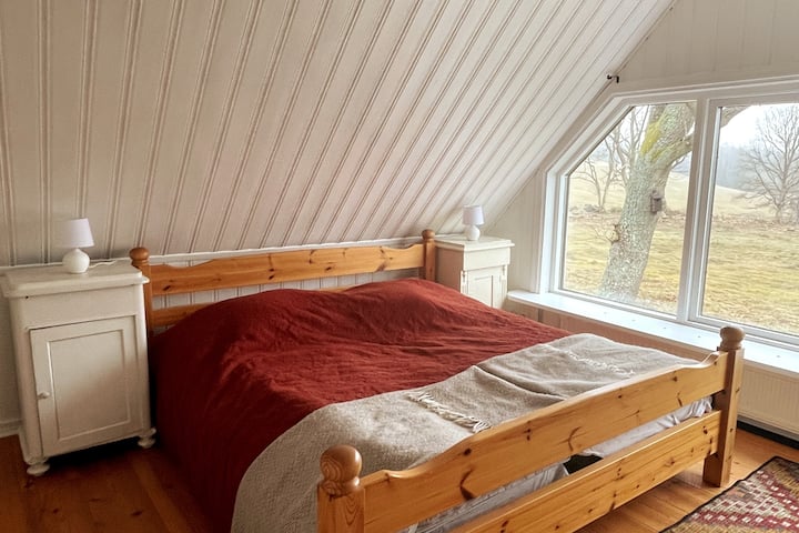 ห้องนอน 1 มีหน้าต่างหน้าจั่วขนาดใหญ่มองเห็นทุ่งหญ้าและทุ่งหญ้า