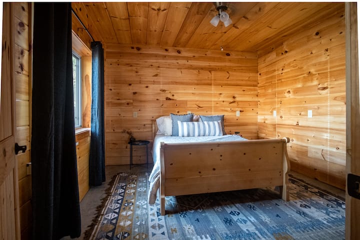 En bas, au sous-sol, se trouve la Richboro Room recouverte de pin avec une grande fenêtre et des rideaux occultants pour un sommeil facile !