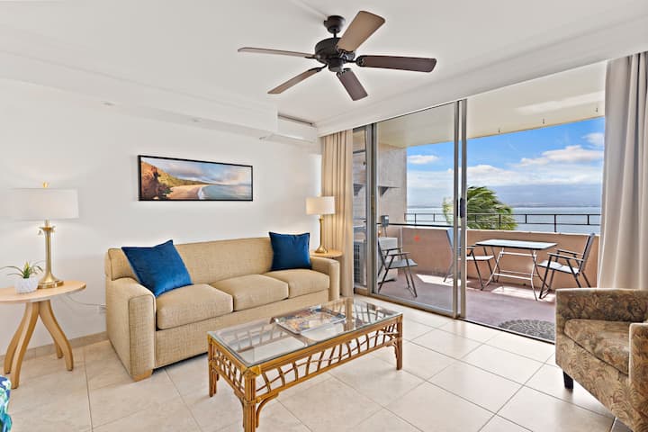 Svetlá obývacia izba s výhľadom na oceán a prístupom na verandu. 