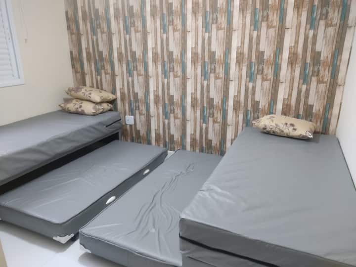 غرفة مفردة بسريرين مربعة وسريرين إضافيين