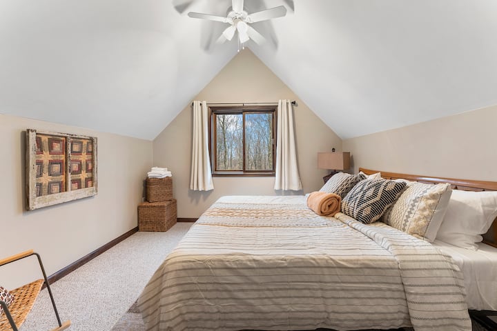 Welcome to our beautiful second-floor king bedroom, where luxury and comfort meet stunning views of the surrounding landscape. With a large closet and ceiling fan, you'll have all the space you need to store your belongings and stay comfortable thro