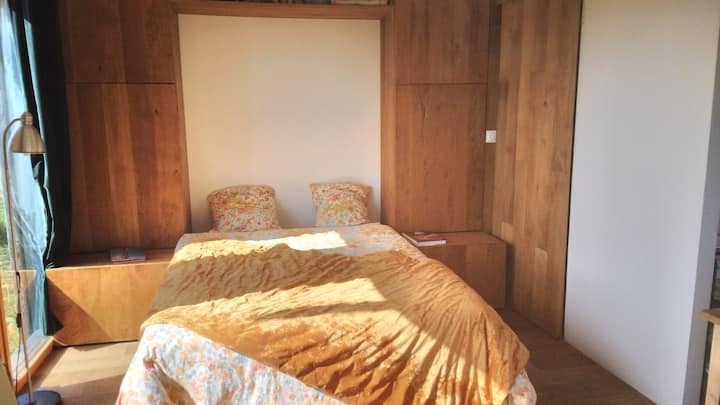 Kitanda kilicho wazi na meza zake kando ya kitanda