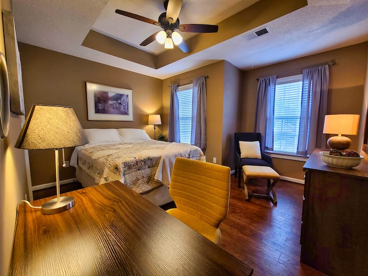 Largest room has lots of natural light, a reading area, and a desk