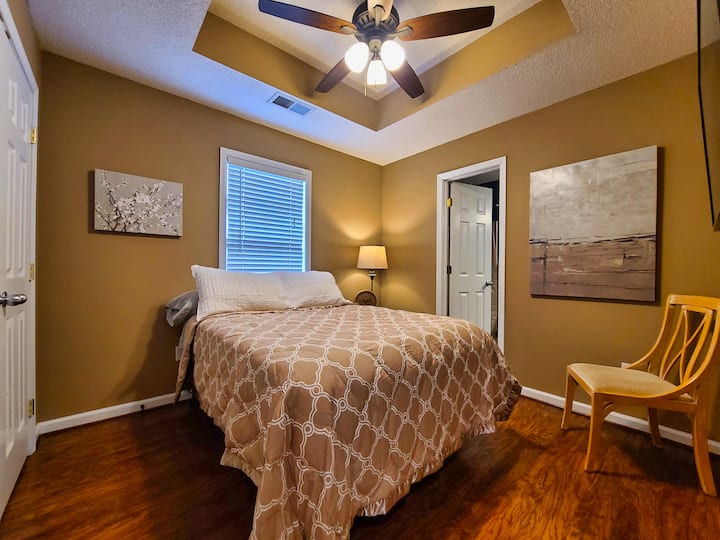 Master bedroom with attached bath and wall-mounted television