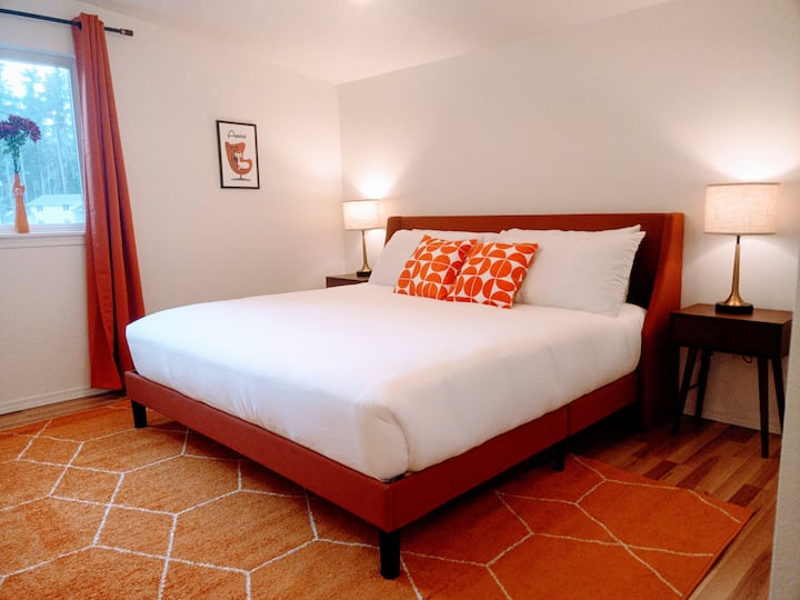 The master bedroom has a king bed colored in vibrant Burnt Orange. There is a retro desk if you need to work while you're here and a full size bathroom attached as well.