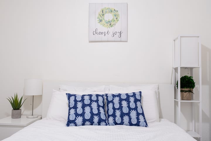 这间温馨的卧室配有舒适的床和柔软的白色床上用品，让您享受宁静的住宿体验。 简约而优雅的设计确保了宁静、轻松的氛围。