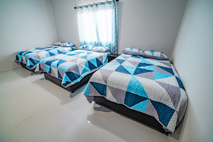 Recámara 1: cuenta con 3 camas matrimoniales, comparte baño