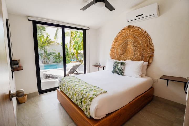 Spálňa s manželskou posteľou na prízemí, obe majú klimatizáciu, stropné ventilátory a skrine.