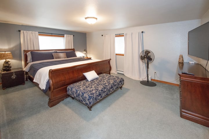 غرفة نوم رئيسية بسرير بحجم كينج ومقعد منجد. تلفزيون ذكي 55بوصة في الغرفة!  اشتكى أحد الضيوف مؤخرًا من أن أسرتنا كانت مريحة للغاية!  حلنا، ابق ليلة إضافية!