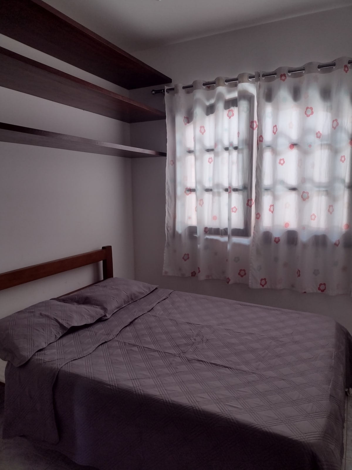 Dormitorio con cama doble y estantes para guardar artículos personales.