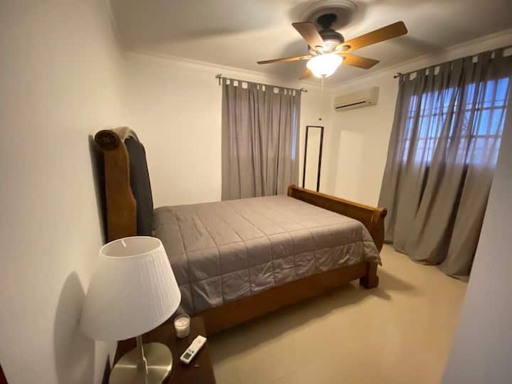 Habitación 2: con cama Queen, aire acondicionado, abanico de techo, closet, y baño al lado.