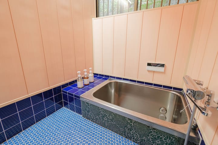 かわいらしいタイルが特徴的なバスルーム。リフォーム済みの水まわりはシンプルで清潔です。オーガニックのボディソープ・シャンプー・コンディショナーを用意しています。