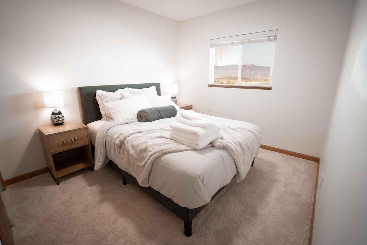 Დედოფლის ზომის სტუმრების საძინებელი, რომელიც წინა დიაპაზონს და პაიკს ‑ პიკს ‑ პიკს გადაჰყურებს