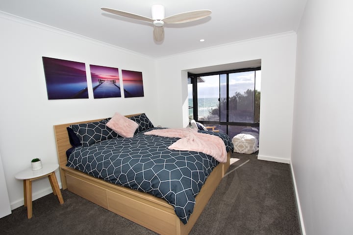 grote slaapkamer - kingsize bed, blokkeer gordijnen, ventilator, airconditioning, hangruimte met kleerhangers, af en toe een stoel om te ontspannen en een boek te lezen.