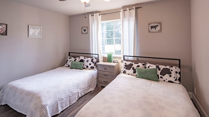 The downstairs bedroom has 2 full beds and a whimsical cow theme