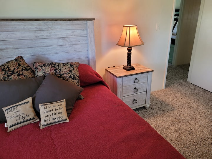 这间舒适的卧室的床头柜上有手机充电站。