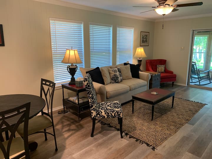 Downstairs living area features sofa bed, game table (with games and puzzles in closet), large streaming TV,  reading material and ceiling fan.