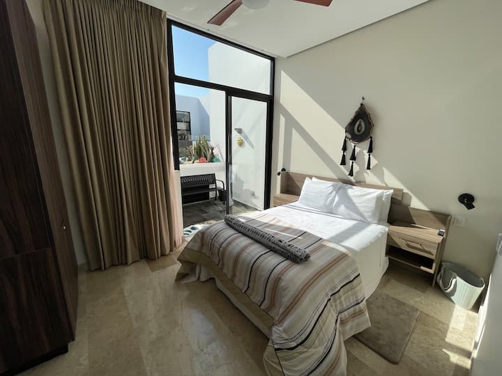 סוויטה עליונה/חדר שינה ראשי. מיטת קיו נוחה מאוד עם מצעים ומצעים חדשים. כניסה למרפסת פרטית, פטיו, גינה ובריכה פרטית (קטנה). בחדר הזה יש מזגן ומאוורר. היחידות מחוברות באמצעות גרם מדרגות קטן עם דלת מאובטחת ונעילה.