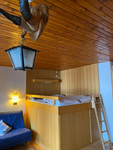 Cama matrimonial elevada en habitación individual