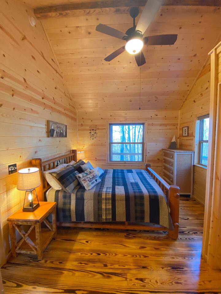 Guest Bedroom with a queen bed,  ceiling fan, two lamps with USB charging, closet, Henry Link wicker dresser and large windows with mountain views.  Vaulted ceiling with lots of natural light.