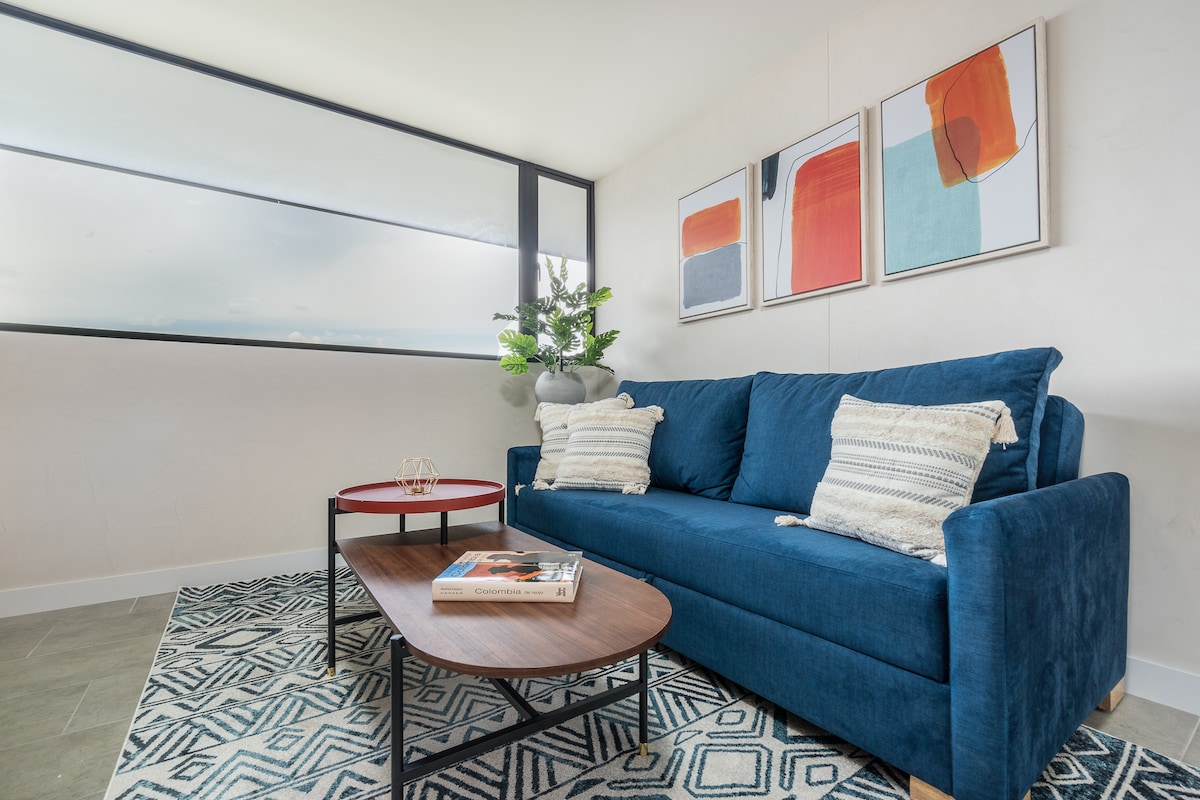 סלון מעוצב עם ספה גדולה ושולחן אוכל, גם גישה למטבח ונוף מדהים לעיר!