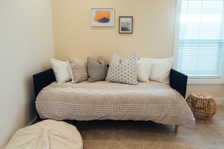 ऊपरी मंज़िल पर मौजूद बेडरूम में एक आरामदेह ट्विन बेड है, जिसमें ताज़ा लिनन, कई परतों वाले तकिए और एक शांत, आकर्षक डिज़ाइन है। अतिरिक्त मेहमानों या सोने की सुविधाजनक जगह के लिए बिल्कुल सही, जहाँ से शेयर्ड जैक-एंड-जिल बाथरूम तक आसानी से पहुँचा जा सकता है