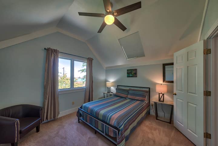 樓上兩間臥室中的一間，配有一張大牀和天窗。 