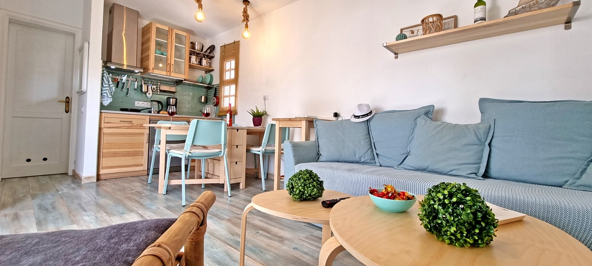 Sala con sofá cama y cocina abierta