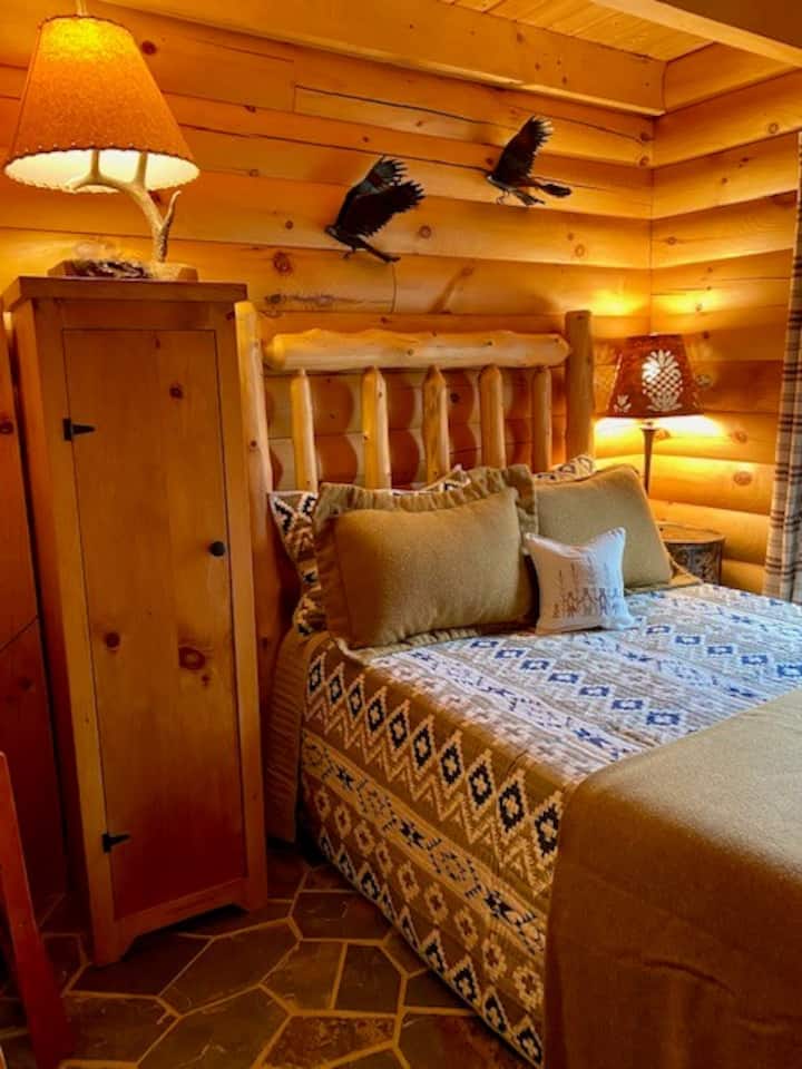 غرفة نوم رئيسية مع مرتبة كاملة من رغوة الذاكرة، ومخزن خزانة جيلي، ومصابيح القصدير المثقبة، ومنحوتات خشب الغراب الطائر من قبل فنان الحياة البرية جيسون تينانت.