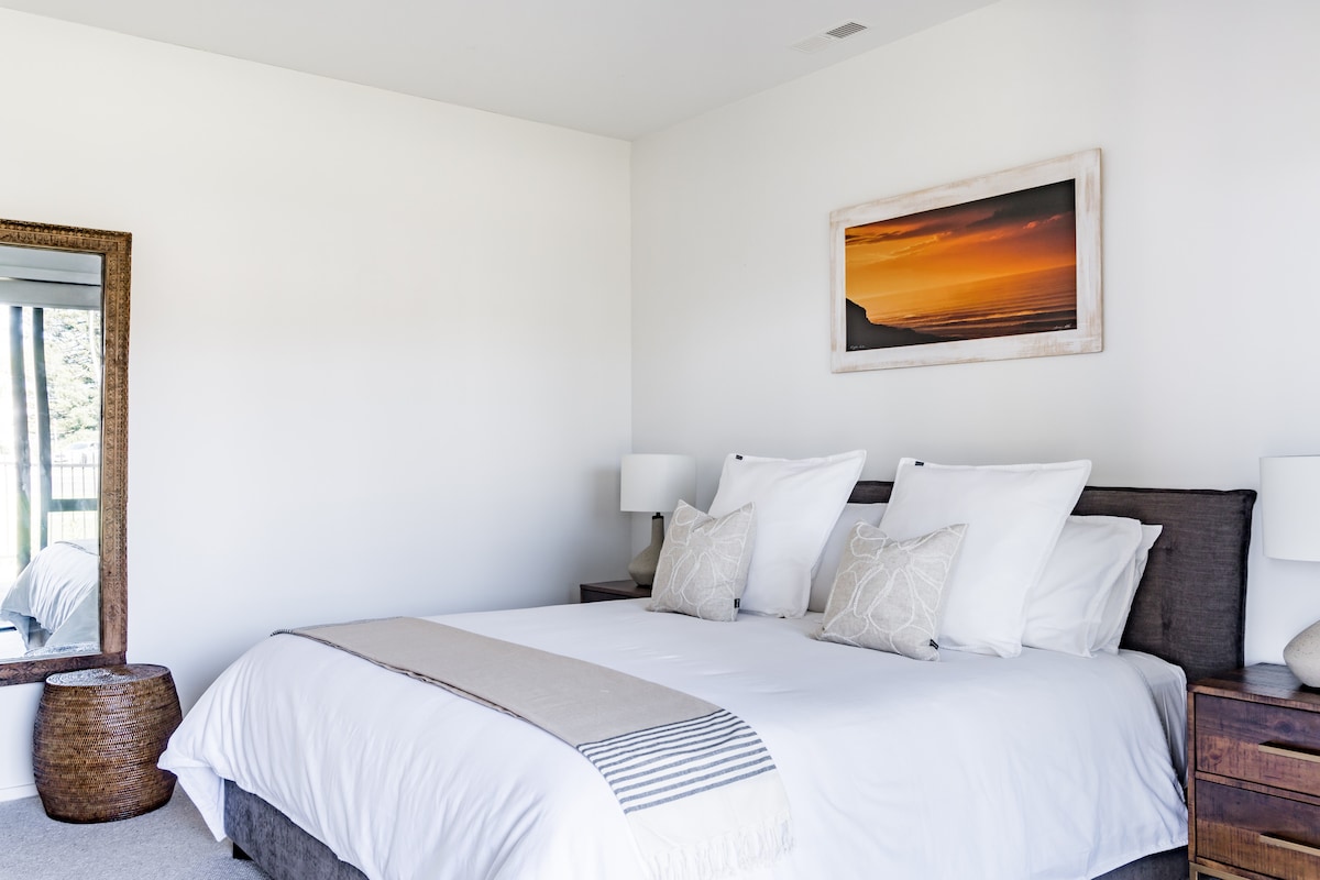 Grote slaapkamer beneden met superkingsize bed, eigen doucheruimte en schuifdeuren naar een eigen terras en tuin