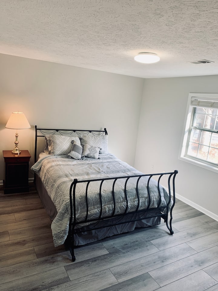 غرفة نوم للضيوف بسرير بحجم كبير وخزانة ملابس وتلفزيون وخزانة ملابس