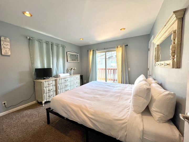 Primarna spavaća soba s komodom i malim televizorom. 