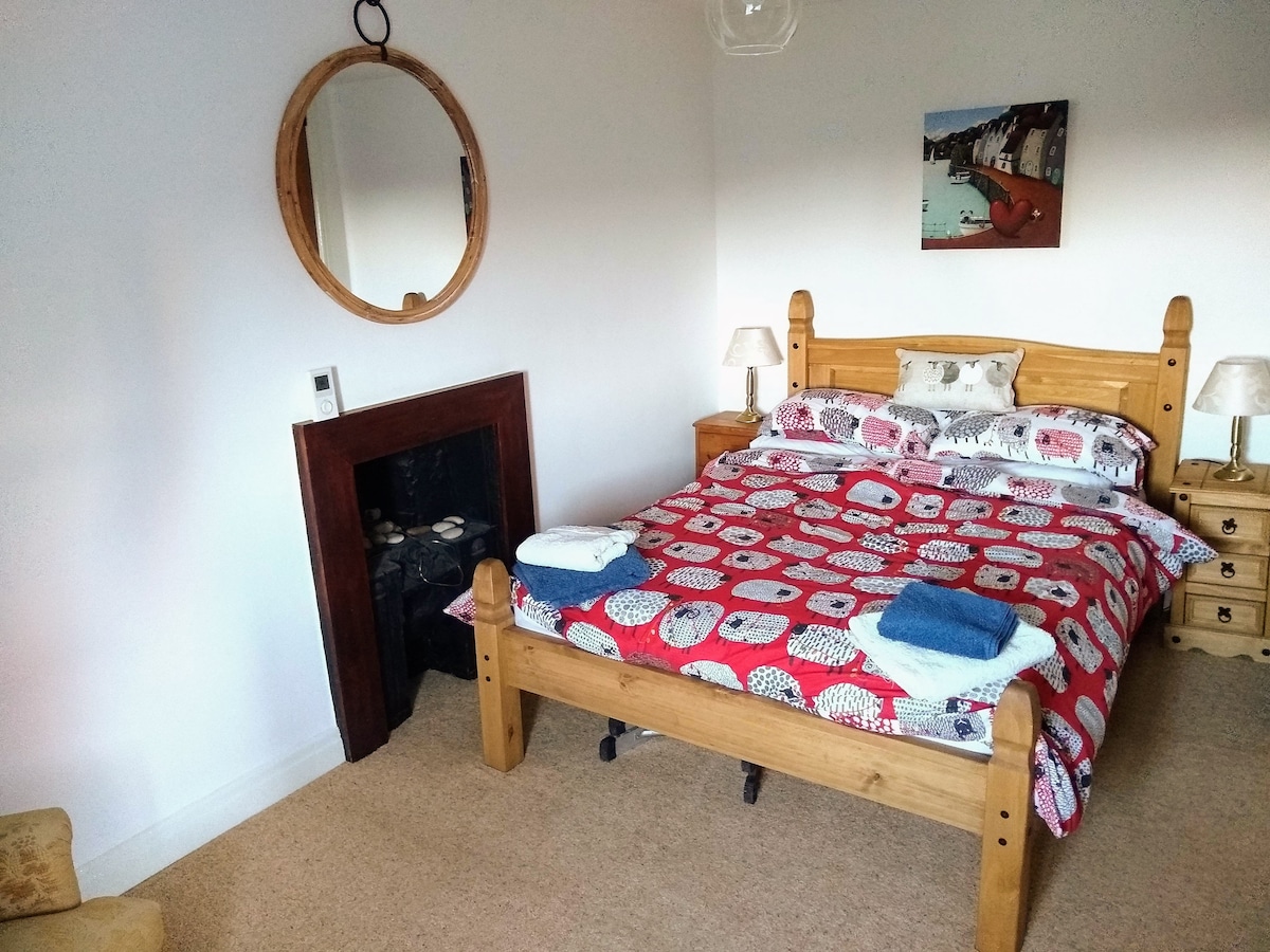 חדר שינה גדול ומרווח עם מיטה זוגית מעץ אלון.