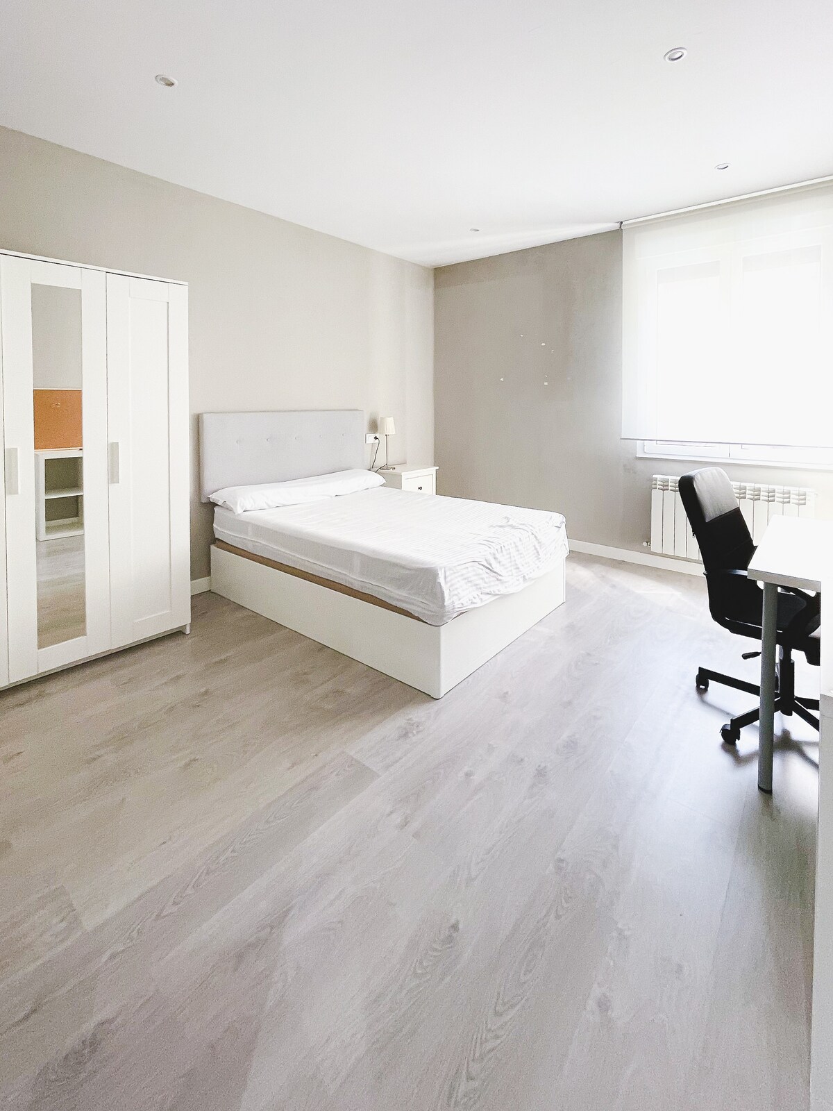 חדר שינה עם מיטה זוגית ואזור עבודה