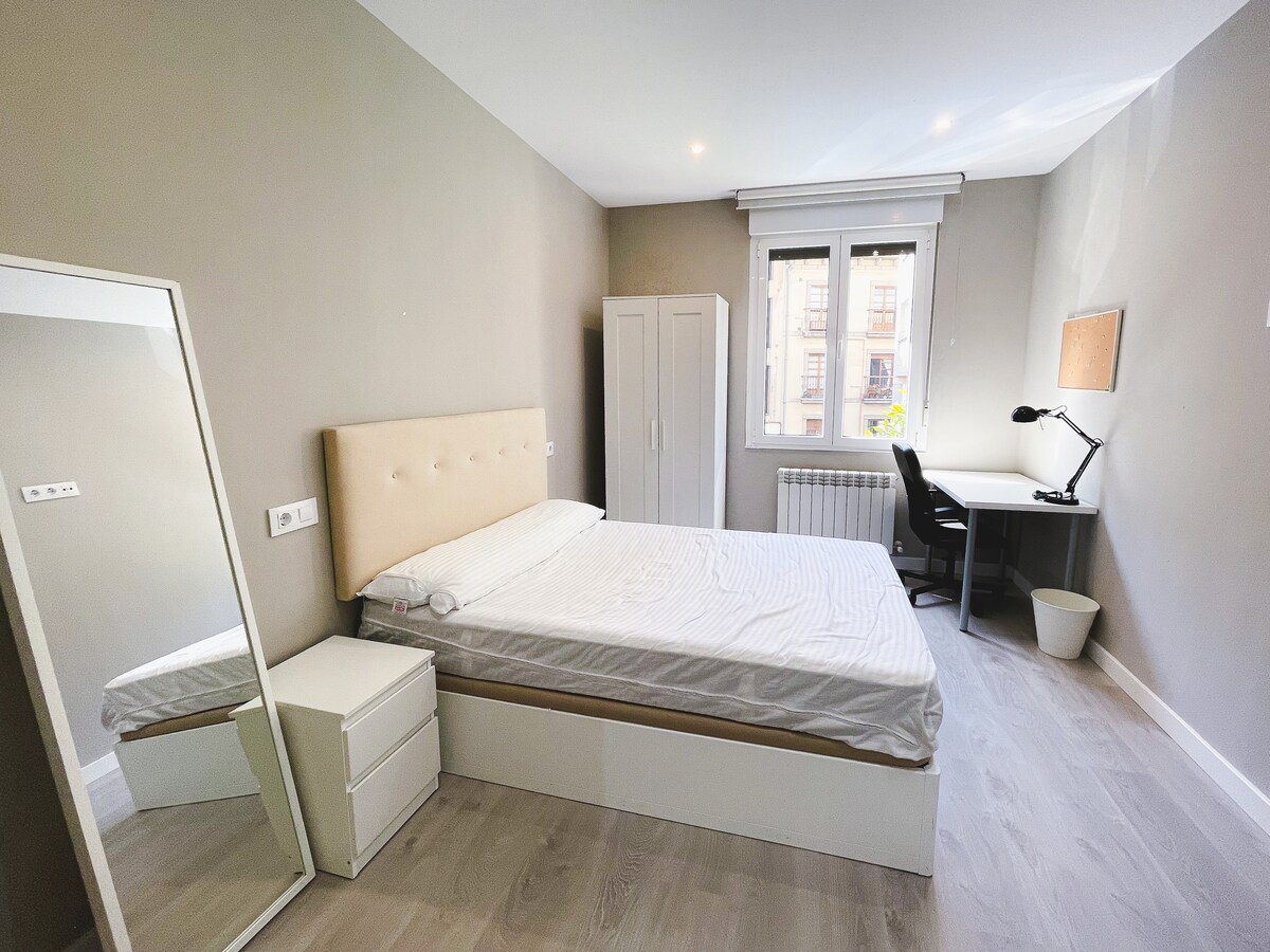 חדר שינה עם מיטה זוגית ואזור עבודה