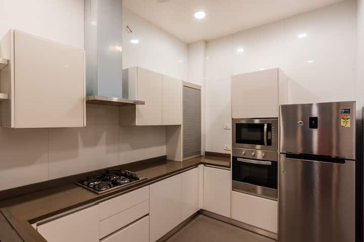 ✨A sleek modular kitchen with glossy white cabinetry, built-in appliances and clean finishes-perfect for effortless cooking and entertaining✨