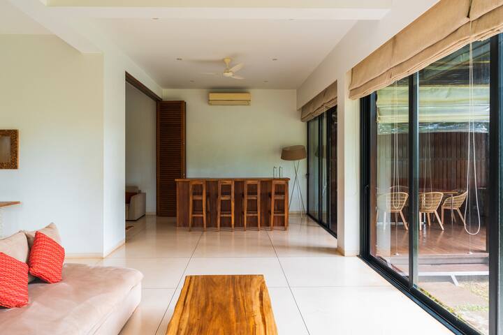 ✨An airy lounge with a wooden bar and glass walls opening to a breezy outdoor space-ideal for relaxed entertaining✨