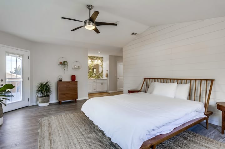 Dormitorio principal con cama tamaño king con baño privado, acceso privado al patio trasero y puerta para perros.