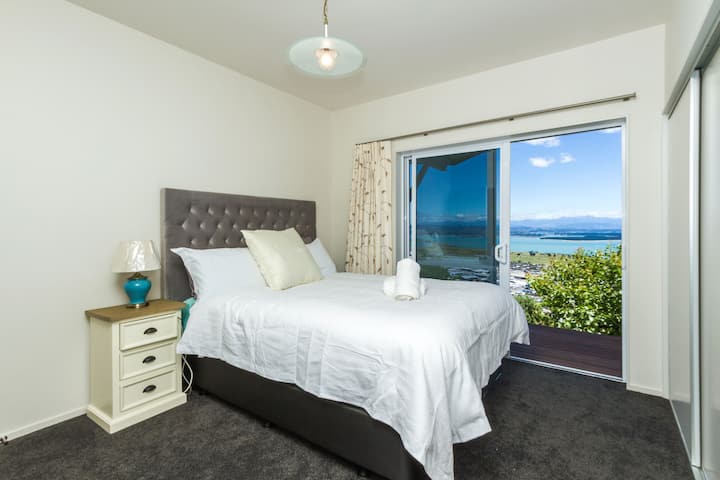 Dormitorio 2 (en la planta baja) con cama tamaño queen y vistas al mar, montaña y jardín.