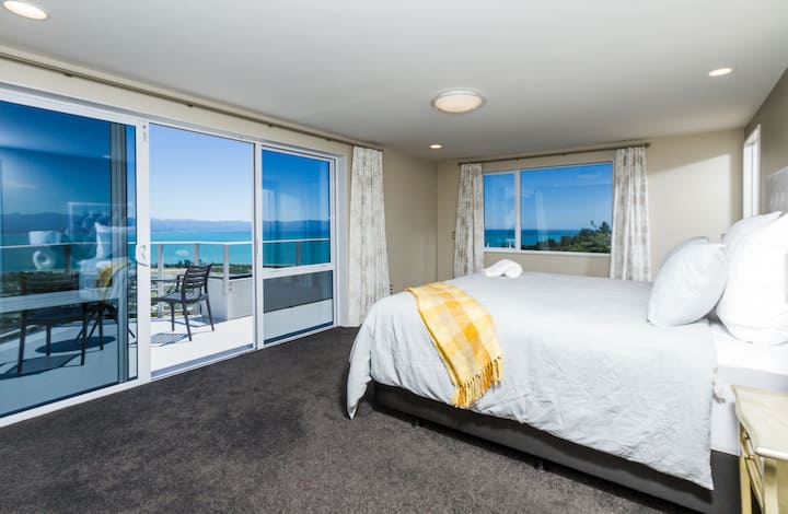 Dormitorio principal (arriba) con cama tamaño king y balcón privado con increíbles vistas al mar y a las montañas.
