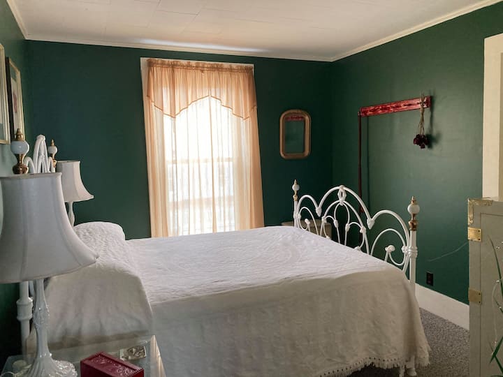 This guest bedroom was designed with care and affection. On the unique antique iron bed frame sits a firm queen sized mattress that will have you sleeping like a baby.