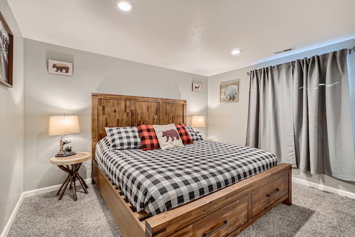 Спална соба со брачен кревет на долниот кат со тема „Ложа“.  Работниот простор со биро што може да се склопи е покрај вратата, веднаш до рамката на камерата.