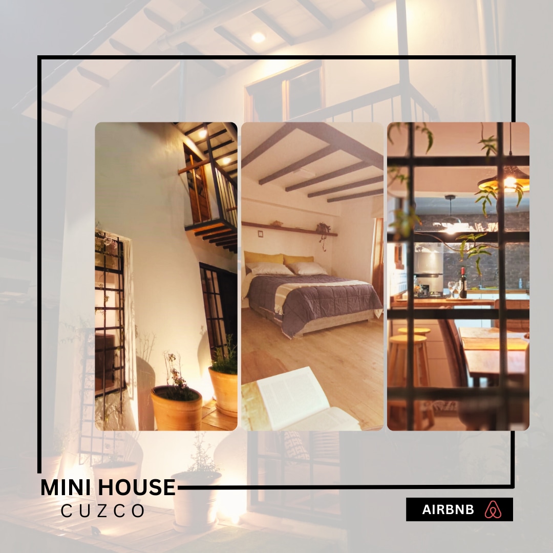 The image displays a three-level mini house with wooden beams and warm lighting. The living space features an inviting atmosphere with plants, while the sleeping area is furnished with a double bed, soft linens, and a view of the kitchen area, showcasing modern appliances.