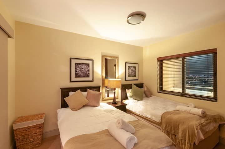 سريران مزدوجان وألوان طبيعية بإطلالة جبلية خارجية.