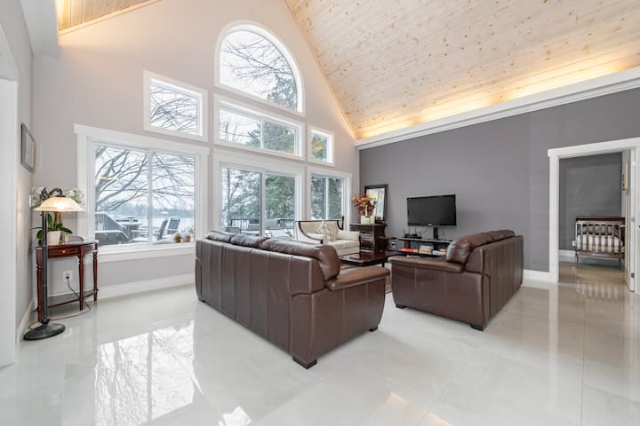 Living room with large windows allowing for a beautiful scenic view no matter the time of year!