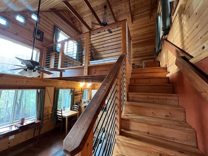 Escaleras al dormitorio de arriba. Disfruta del impresionante interior de madera con una cálida luz que entra. 